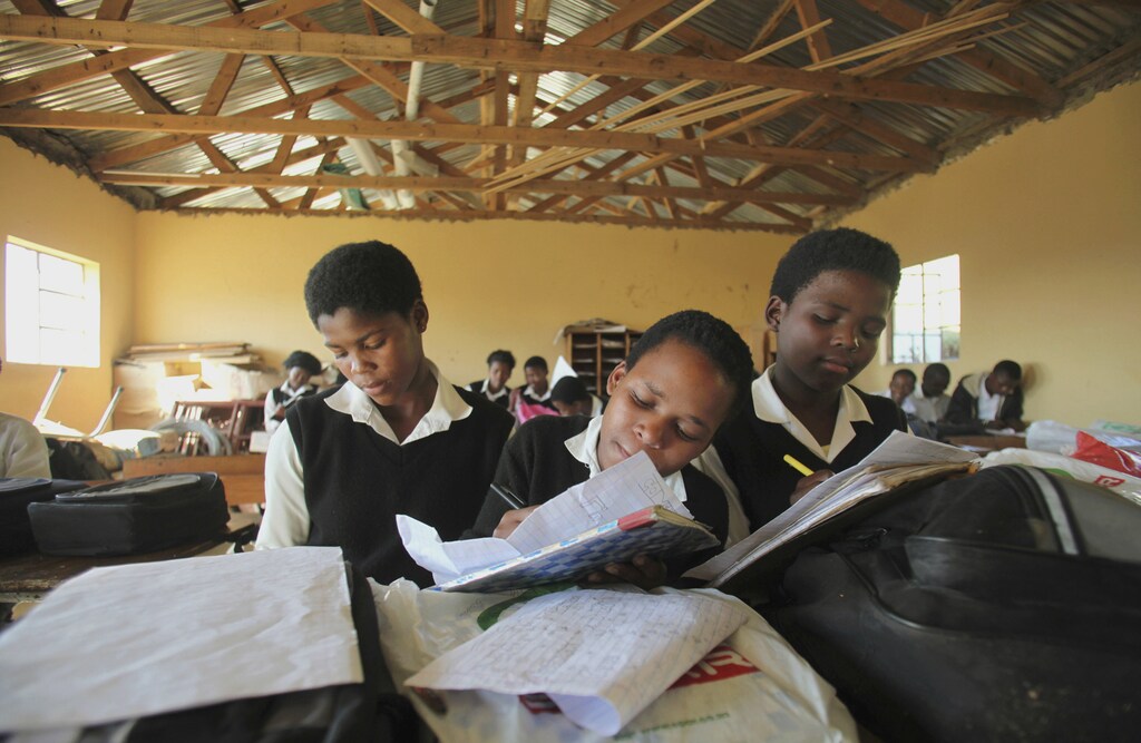 Children write notes from a makeshift black board at a school in Mwezeni village in South Africa's Eastern Cape Province in this picture taken June 5, 2012. The Eastern Cape, home to giants of the African National Congress like Nelson Mandela and Walter Sisulu who helped end apartheid and Thabo Mbeki, the nation's second democratically elected president, is a glaring example of the ruling party's failure to deliver its promise of a "better life for all". While thousands of schools wait each year for textbooks and many Eastern Cape children are forced to write on loose sheets, the ANC has produced copious reams of policy papers to be studied by about 3,000 delegates at next week's meeting. Picture taken June 5, 2012. To match Insight SAFRICA-ANC/ REUTERS/Ryan Gray (SOUTH AFRICA - Tags: EDUCATION POLITICS) - GM1E86O1TK601