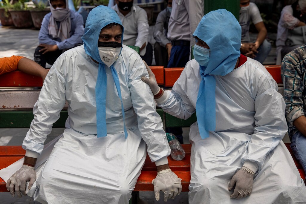 A man is consoled by his brother after their father died due to the coronavirus disease (COVID-19), at a crematorium ground in New Delhi, India, April 28, 2021. REUTERS/Danish Siddiqui - RC2U4N9PUJ9W