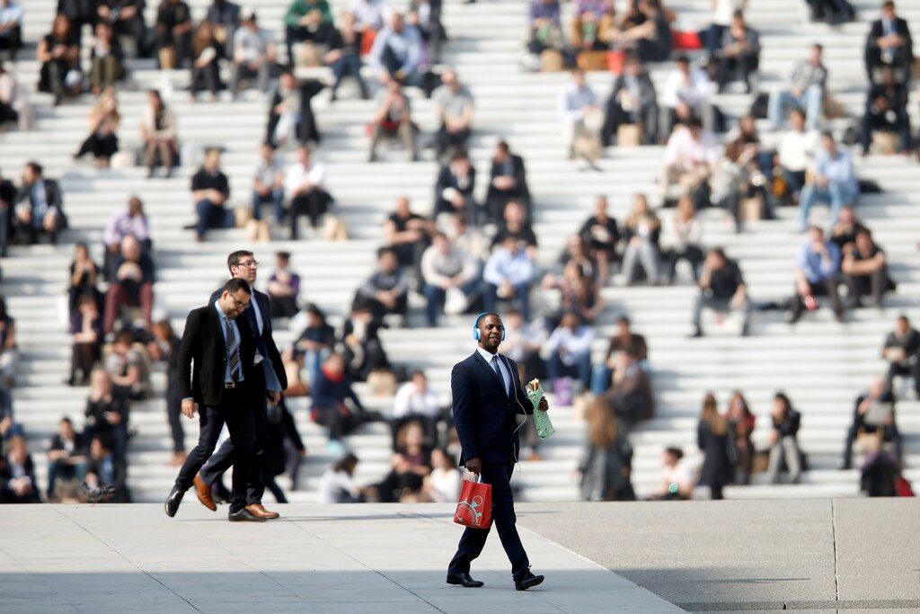 Businessmen enjoy the good weather at lunch time under the Arche de la Defense, in the financial and business district west of Paris, as warm and sunny weather continues in France, March 13, 2014. REUTERS/Charles Platiau/File Photo GLOBAL BUSINESS WEEK AHEAD PACKAGE - SEARCH 'BUSINESS WEEK AHEAD 31 OCT' FOR ALL IMAGES - RTX2R4OZ