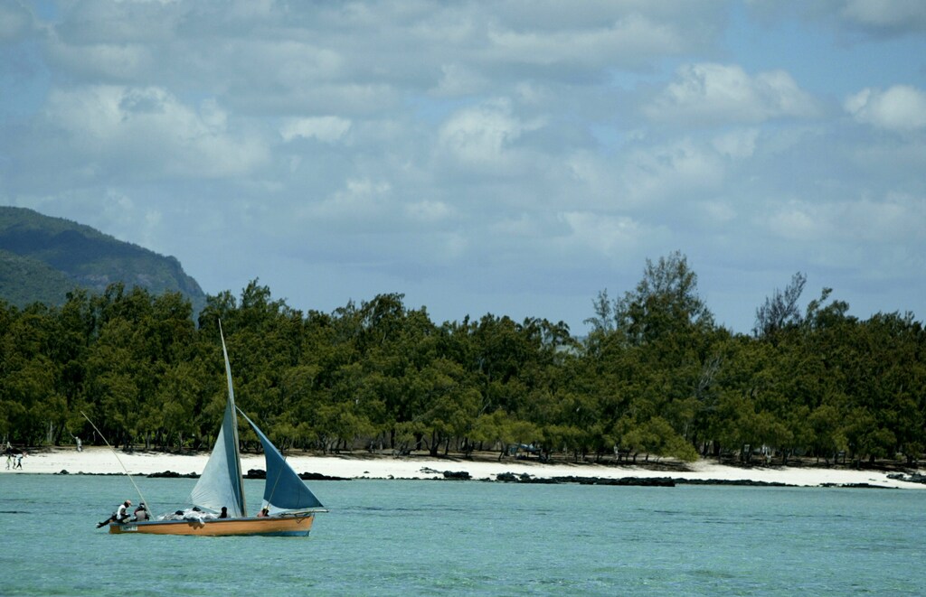 A small fishing boat cruises along the East coast of Mauritius near Ile aux Cerfs which has one of the most picturesque and spectacular beaches on the Indian Ocean island, November 13, 2003. Although surrounded by thousands of miles of ocean, the island's fishing industry has never been developed on a large scale.NO RIGHTS CLEARANCES OR PERMISSIONS ARE REQUIRED FOR THIS IMAGE REUTERS/Darrin Zammit Lupi DZL - RTR7PFQ