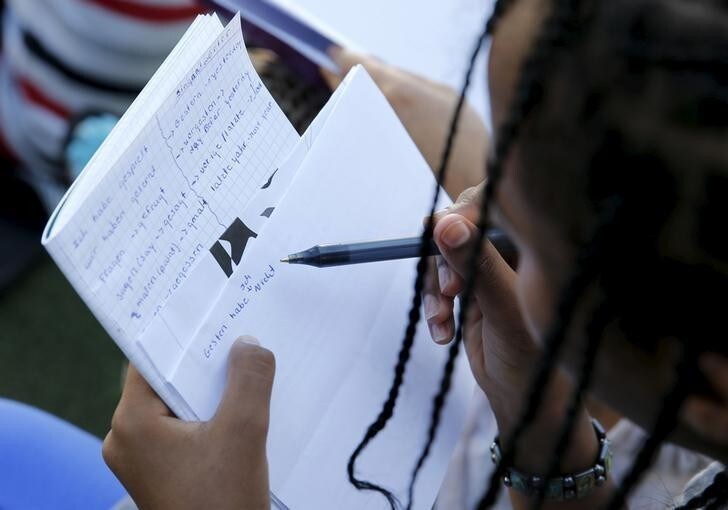 A asylum seekers from Eritrea makes notice during a German language instruction by a volunteer at an emergency reception centre for asylum seekers in Berlin's district Moabit, Germany, August 3, 2015. REUTERS/Fabrizio Bensch