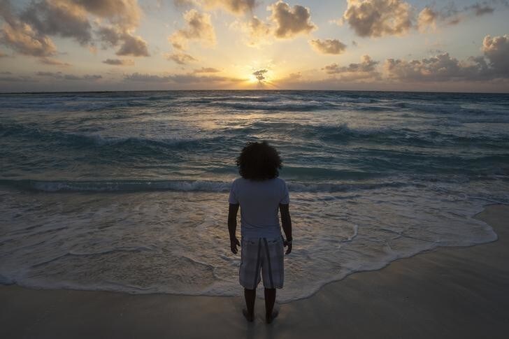 A man watches the sunrise on New Year's Day at Gaviota Azul beach in Cancun January 1, 2014. REUTERS/Victor Ruiz Garcia (MEXICO - Tags: SOCIETY ENVIRONMENT TPX IMAGES OF THE DAY)