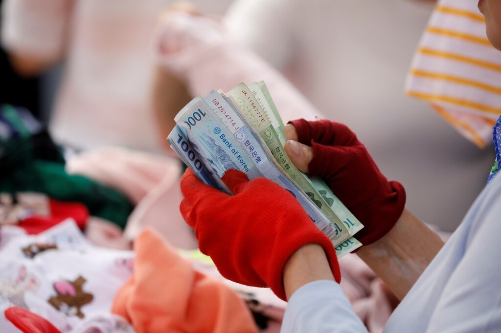 A street vendor counts his money at the Namdaemun Market in Seoul, South Korea, May 30, 2017. Picture taken on May 30, 2017. REUTERS/Kim Hong-Ji - RTX38GCE
