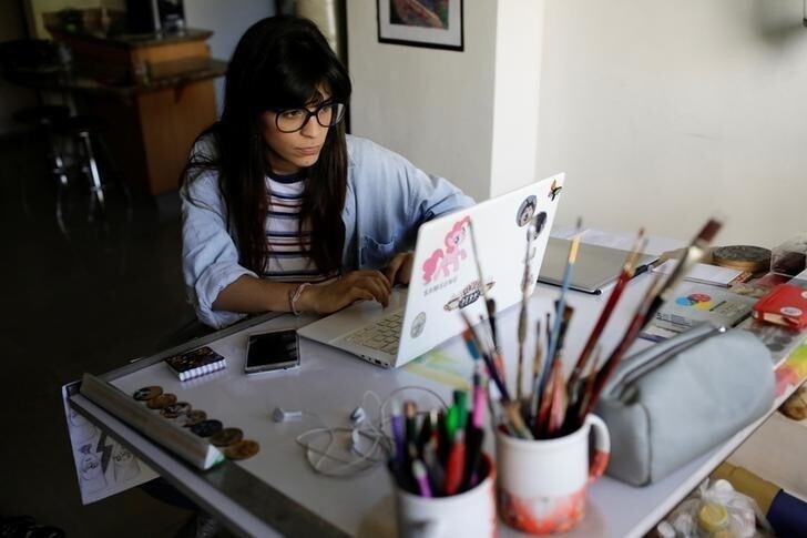 Valentina Maggi works on her computer at her home in Caracas, Venezuela April 9, 2018. Picture taken April 9, 2018. REUTERS/Marco Bello