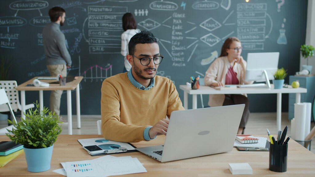 Un hombre, una computadora portátil, un teléfono inteligente, una oficina, innovación, tecnología, acceso, bienes comunes digitales.