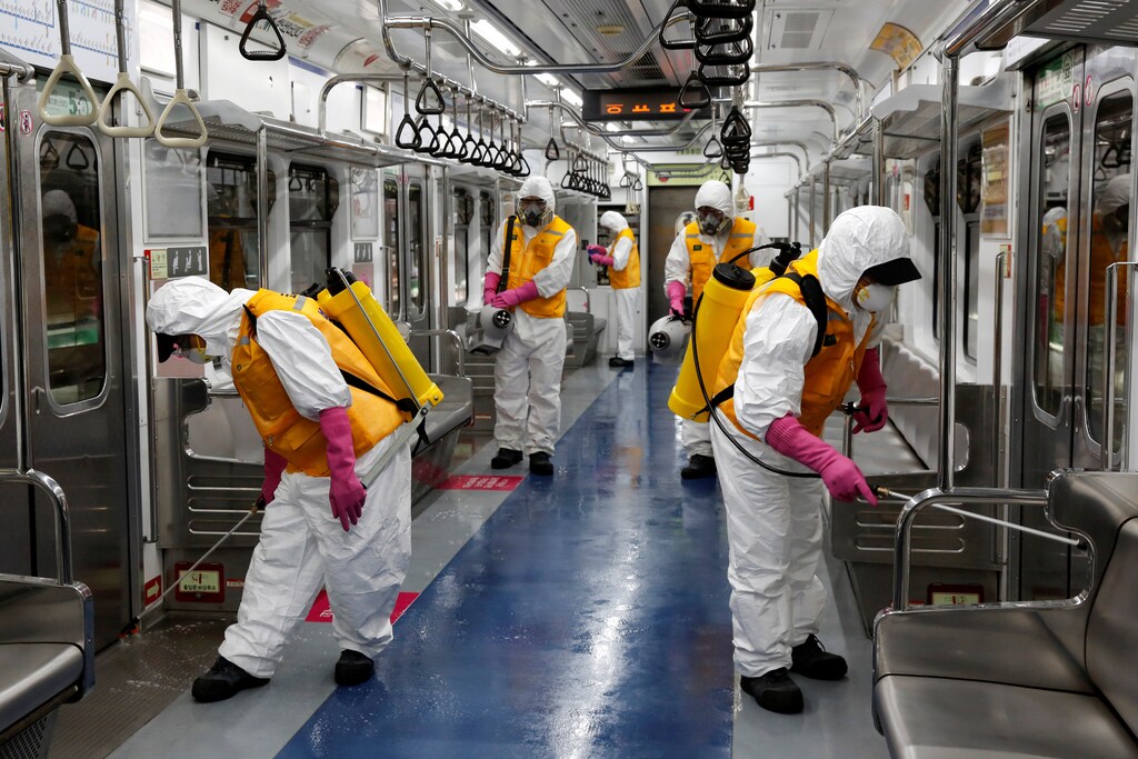 Empleados de una empresa de servicios de desinfección desinfectan un depósito de vagones de metro en medio de temores de coronavirus en Seúl, Corea del Sur, el 11 de marzo de 2020.