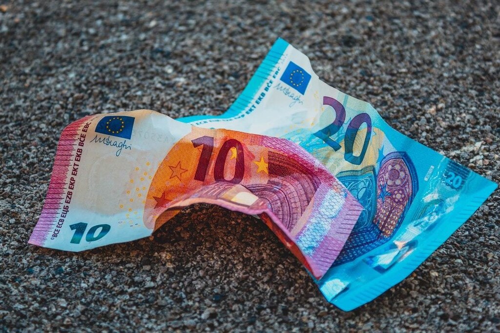 Notes of euros are pictured scrunched up on the floor.