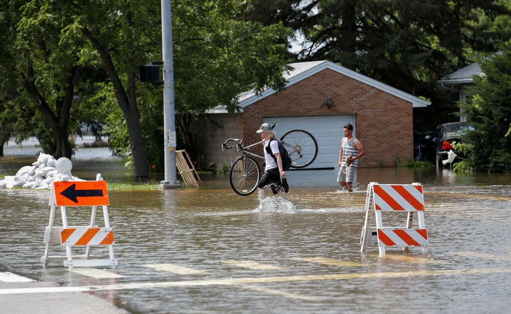 Men walk through a flooded area in Gurnee, Illinois, U.S. July 15, 2017. REUTERS/Kamil Krzaczynski - RTX3BLXL