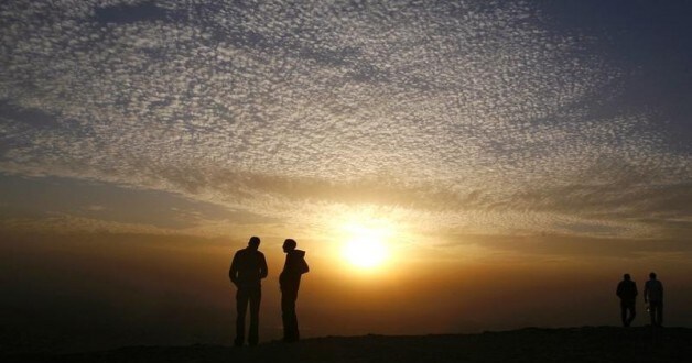 Young men talk on the top of a hill overlooking Cairo during sunset, November 25, 2008. REUTERS/Asmaa Waguih