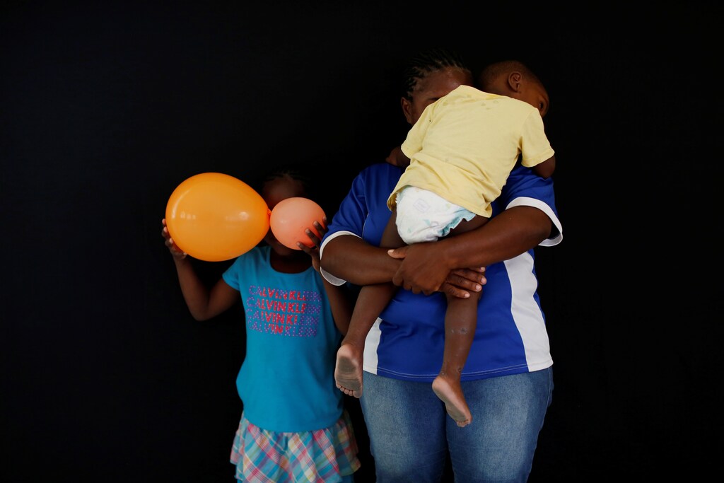 A woman from Honduras who didn't want to be identified and who is hoping to get refugee status in Mexico, poses for a photograph with her children at a migrant shelter, known as The 72, in Tenosique, Tabasco, Mexico, April 12, 2017. "I left Honduras because of violence and extortion from gang members," she said. REUTERS/Carlos Jasso SEARCH "IMMIGRANTS JASSO" FOR THIS STORY. SEARCH "WIDER IMAGE" FOR ALL STORIES. - RTS15ANS
