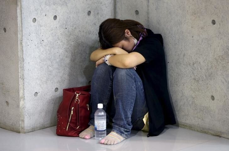 An evacuee from an area flooded by the Kinugawa river, caused by typhoon Etau, takes a rest at Ishige Sports Park acting as an evacuation center in Joso, Ibaraki prefecture, Japan, September 10, 2015. Japan evacuated about 100,000 people from their homes on Thursday, after rare torrential rains unleashed floods that left at least two people missing and stranded many more when rivers surged over their banks. REUTERS/Issei Kato