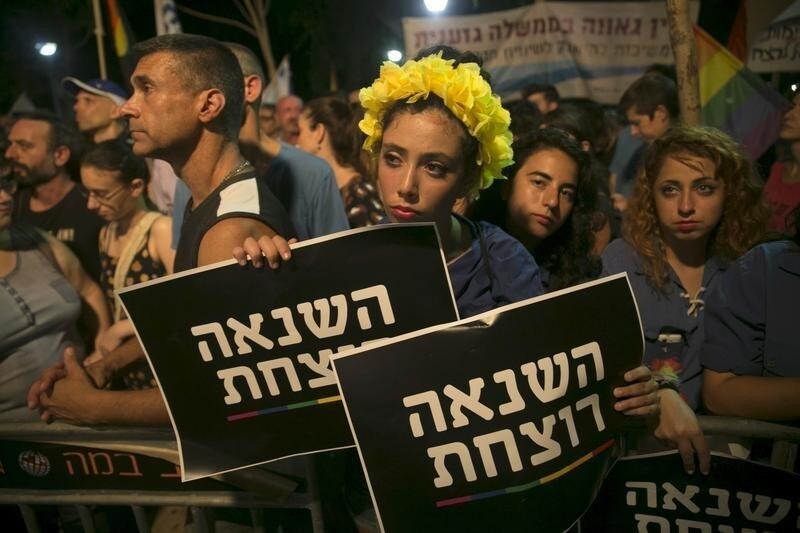A woman holds signs during a protest against the violence towards the gay community in Tel Aviv August 1, 2015. Thousands came to show solidarity after an ultra-Orthodox Jewish man stabbed and wounded six participants, two of them seriously, in the annual Gay Pride parade in Jerusalem on Thursday, with police saying the suspect was jailed for a similar attack 10 years ago. The sign reads "hatred kills". REUTERS/Baz Ratner TPX IMAGES OF THE DAY - GF20000011127
