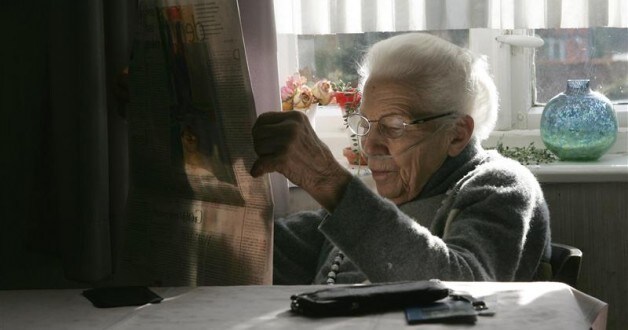 Ilse Westphal, 92-year-old, reads the newspapers as she receives her daily oxygen therapy for a chronic pulmonary disease, in the living room of her farmhouse in the small village of Gross Lafferde near Hanover, northern Germany, April 15, 2006.