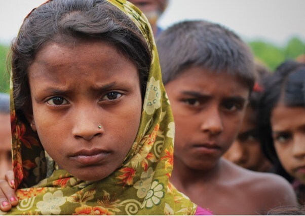 A girl with a green scarf over here head, looking concerned.
