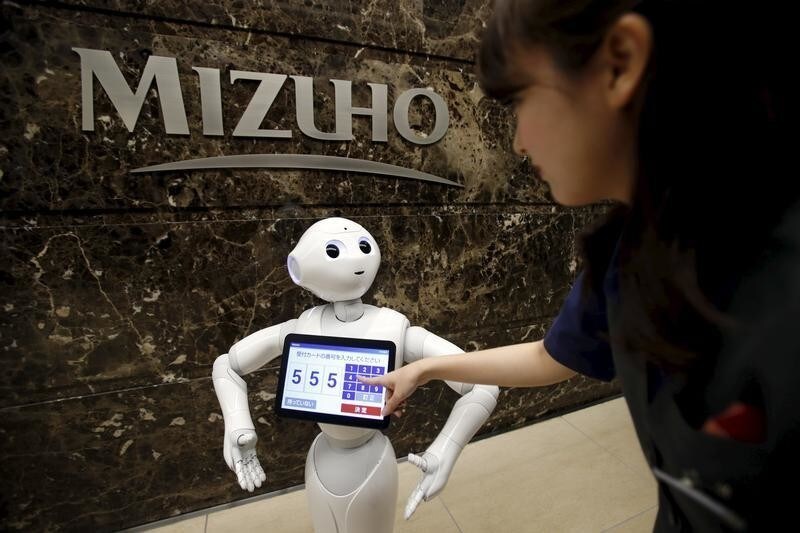 SoftBank's human-like robot named "Pepper" demonstrates how to welcome a customer as a concierge during a photo opportunities at an entrance of Mizuho Financial Group's Mizuho bank branch in Tokyo, Japan, July 17, 2015. Pepper starts working as a concierge of the bank to welcome customers. REUTERS/Yuya Shino - GF10000161538