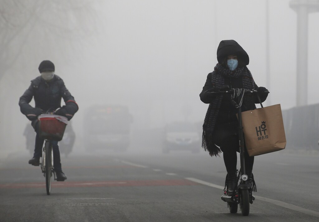 People ride amid the smog in Beijing, China, February 14, 2017. REUTERS/Jason Lee - RTSYJAS