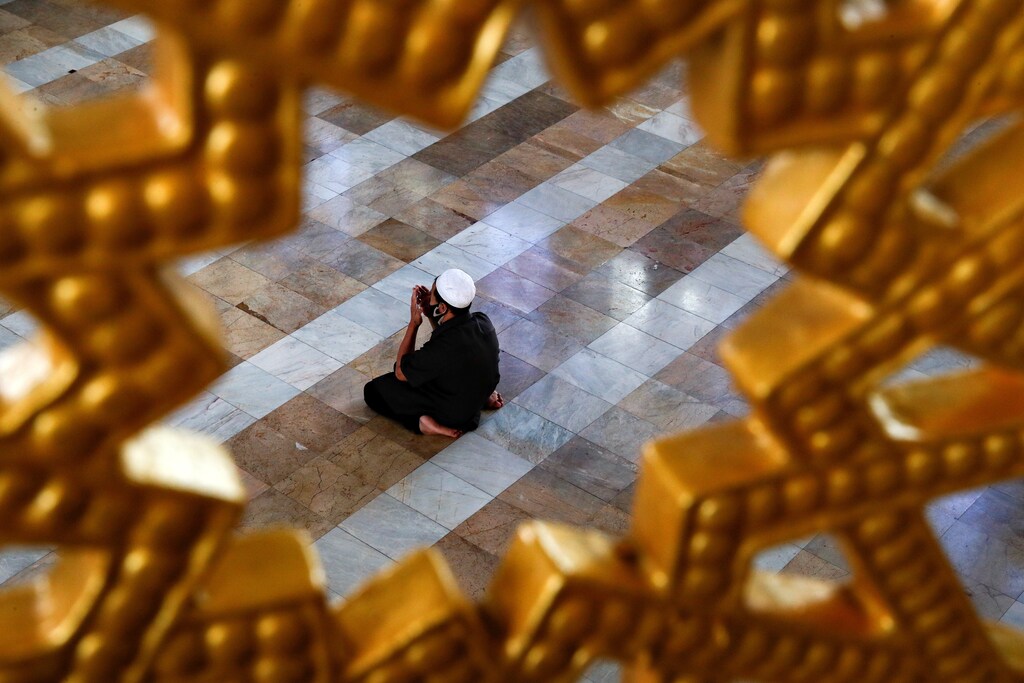 A Muslim man wearing a protective face mask prays at a mosque on the first day of the holy fasting month of Ramadan, amid the coronavirus disease (COVID-19) outbreak, in Bangkok, Thailand April 24, 2020. REUTERS/Jorge Silva TPX IMAGES OF THE DAY - RC2UAG9U8UU5