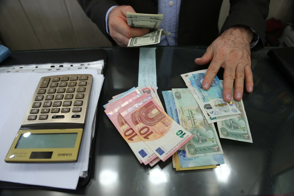 A money changer holds U.S. dollar banknotes as he counts other currency banknotes at Grand Bazaar in Tehran, Iran October 14, 2017. Nazanin Tabatabaee Yazdi/TIMA via REUTERS ATTENTION EDITORS - THIS IMAGE WAS PROVIDED BY A THIRD PARTY. - RC1B64997900