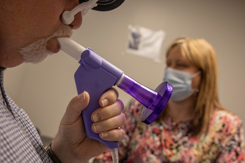Danny Bailey, 70, a retired coal miner, performs a spirometry test as part of his annual health examination with respiratory therapist Tammy Viers at Stone Mountain Health Services in Vansant, Virginia, U.S., April 14, 2025. The test measures lung function and is commonly used to monitor respiratory conditions such as black lung disease, which affects many former miners exposed to coal dust.