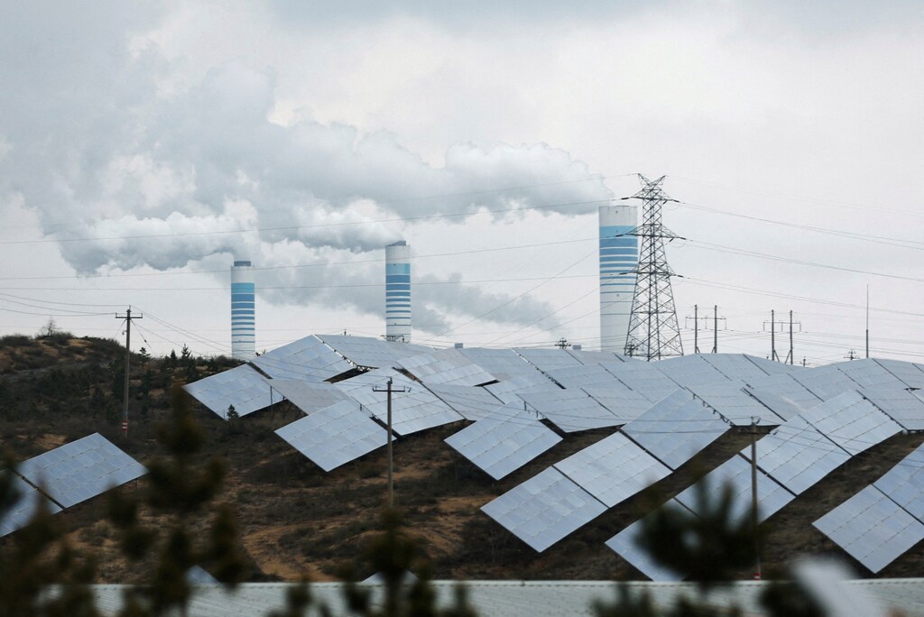Smoke rises from chimneys near solar panels, during a Huawei-organised media tour, in Shaanxi province, China April 24, 2023: Countries are investing heavily in clean energy in different ways