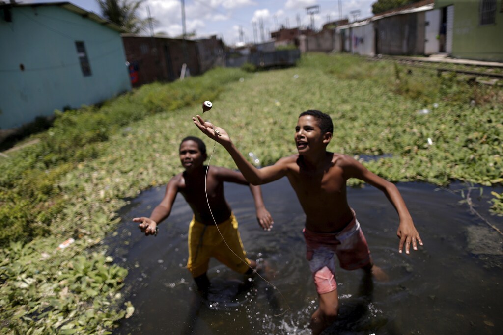 Children play in water at a slum in Recife, Brazil, March 2, 2016. REUTERS/Ueslei Marcelino