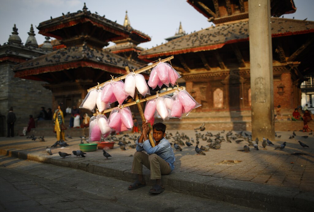 Satrohan Kumar Sahani, 12, sells cotton candy as he waits for customers along the street at Hanumandhoka Durbar Square in Kathmandu March 18, 2013.