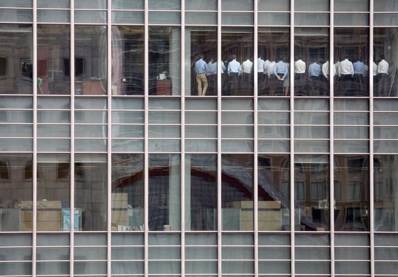 Bankers attend an emergency meeting at the London office of Lehman Brothers, in the financial district of Canary Wharf in London, Britain, September 11, 2008. The photograph caught the moment when Gwion Moore, one of those pictured in the photograph, and his colleagues were being told by bosses that things were going to be OK, despite the plummeting Lehman Brothers share price. "Senior management thought they needed to get the workforce focused again," Moore said. "The phrase was stop 'goofing around and get back to work'. I don't think anyone took the message very seriously because we went back to doing what we had been doing beforehand. No one was going to trade with us."
