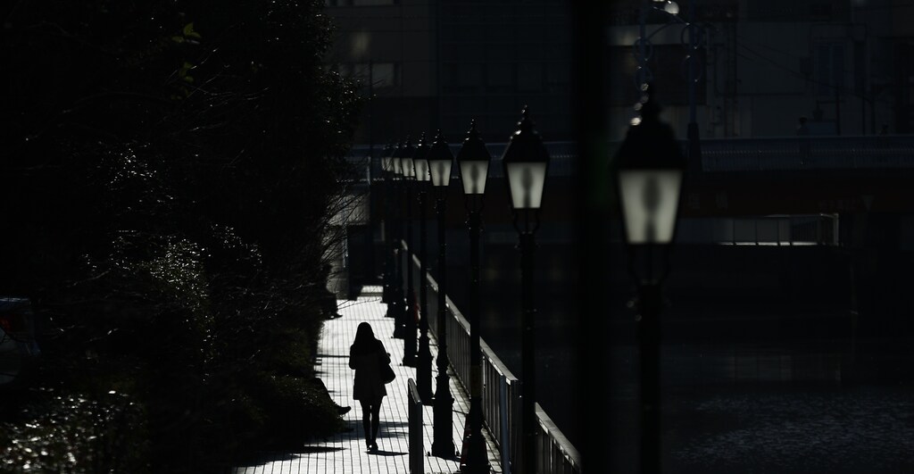 A woman walks along a canal on a sunny day in Tokyo, Japan, March 3, 2016.