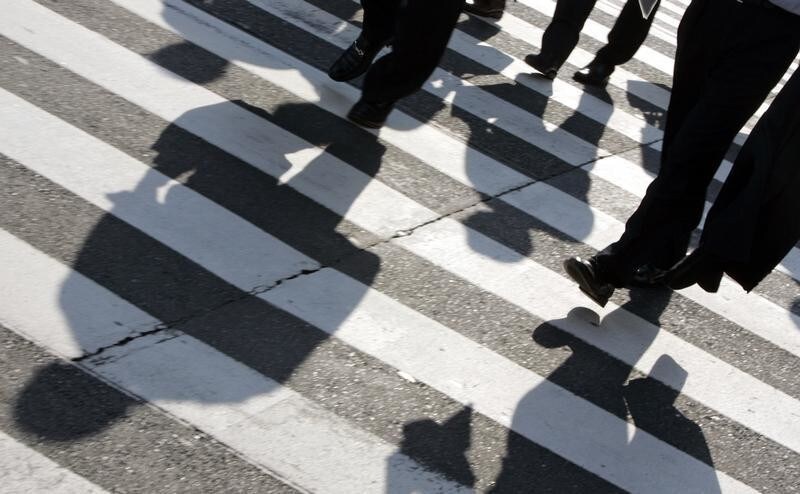 Businessmen cast shadows as they cross a street in Tokyo's Marunouchi district July 25, 2007. The Japanese government will release preliminary gross domestic product (GDP) data for the April-June quarter on August 13, the Cabinet Office said, just ahead of central bank review at which it is expected to raise rates. REUTERS/Yuriko Nakao (JAPAN) - GM1DVTXXVFAA