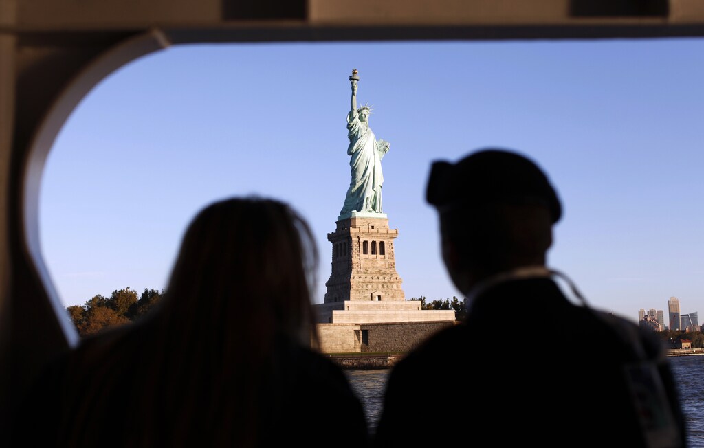 A couple of new citizens view the Statue of Liberty as they ride the ferry to Liberty Island in New York harbor October 28, 2011. New citizens were sworn in during ceremonies marking the 125th anniversary of the Statue at Liberty Island in New York, October 28, 2011. REUTERS/Mike Segar