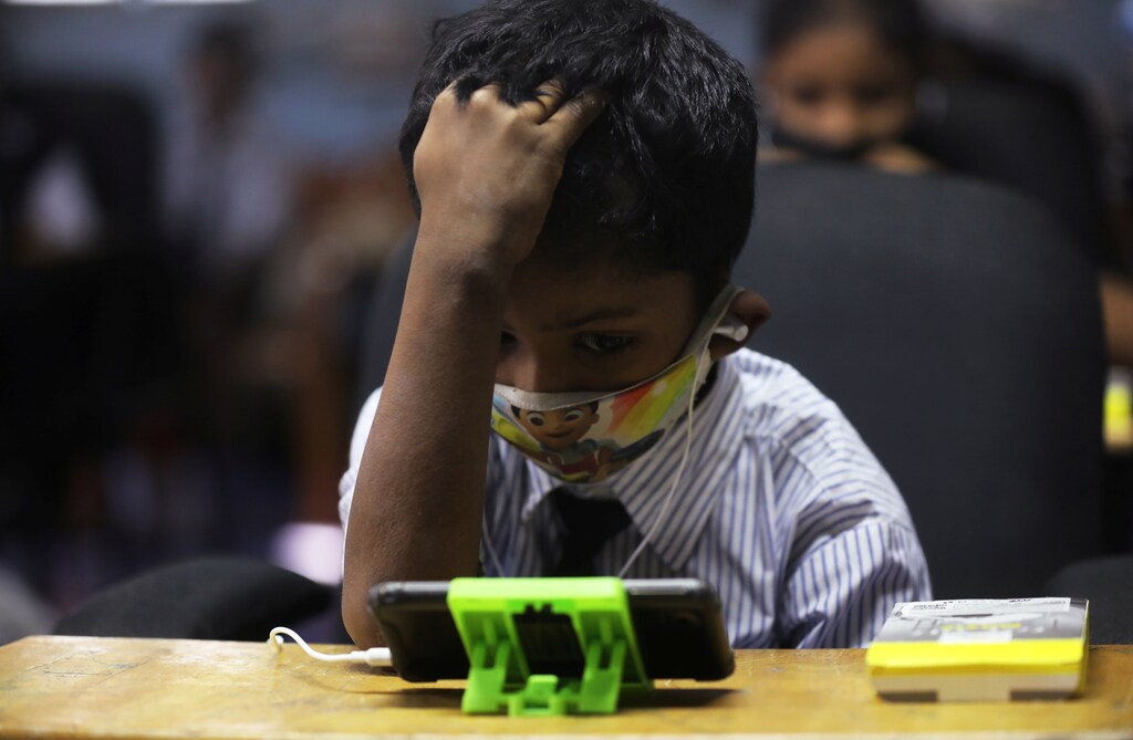 A student watches an online lecture on a mobile phone, inside a digital mobile education library, initiated to provide mobile phones to chidren who have no access to them for their education classes amidst the spread of the coronavirus disease (COVID-19) in Mumbai, India, October 16, 2020. REUTERS/Francis Mascarenhas - RC2KJJ932W9L