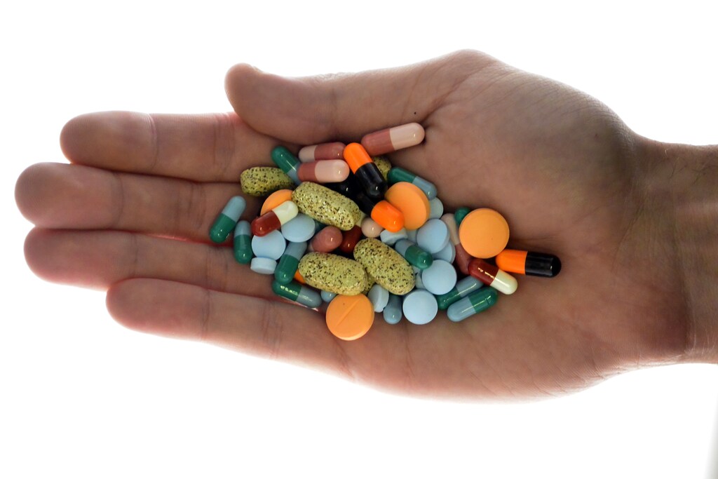 A person holds pharmaceutical tablets and capsules in this picture illustration taken in Ljubljana September 18, 2013