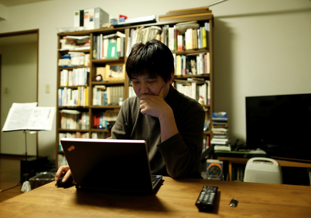 Seijiro Katsura, a 44-year-old office worker, checks market rates for investment opportunities using his laptop computer at his home in Tokyo, Japan December 10, 2016. Picture taken December 10, 2016. REUTERS/Issei Kato - RC129D1D24F0
