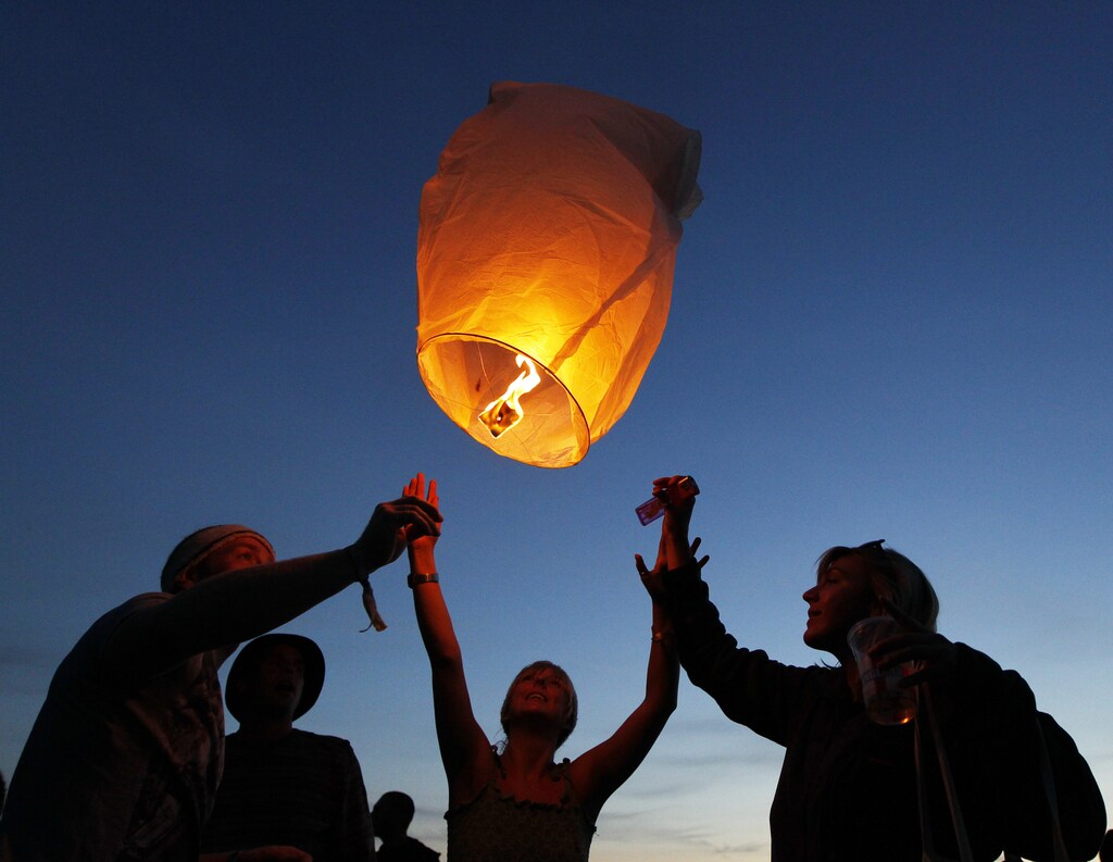 Festival goers set off paper lanterns at nightfall at the Glastonbury Festival 2010 in south west England, June 23, 2010. Glastonbury, one of the top summer music festivals in western Europe, runs from June 23-27. Picture taken June 23, 2010. REUTERS/Luke MacGregor (BRITAIN - Tags: ENTERTAINMENT SOCIETY) - GM1E66O1H4801