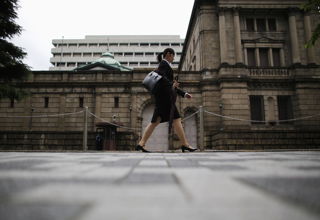 A woman walks past the Bank of Japan headquarters in Tokyo July 2, 2012. Japanese manufacturers were less pessimistic about business conditions in the three months to June, the central bank's closely watched tankan survey showed, a sign that the economy was on track for a moderate recovery despite the pain from Europe's debt crisis and slowing overseas growth. REUTERS/Toru Hanai (JAPAN - Tags: BUSINESS SOCIETY) - GM1E872125P01