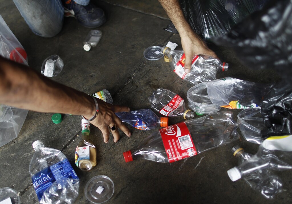 Worker separates plastic bottles at a recycling depot in Panama City September 12, 2013. The National Association for the Conservation of Nature (ANCON) reports that the majority of Panama City's beaches and rivers are contaminated with plastic and general waste due to lack of awareness for waste management, causing major problems for fishermen and negative impact on mangroves and their wildlife. According to the Plastic Oceans Foundation, more plastic has been produced over the last ten years than over the whole of the last century. Picture taken September 12, 2013. REUTERS/ Carlos Jasso (PANAMA - Tags: ENVIRONMENT SOCIETY) - GM1E99I1RKF01