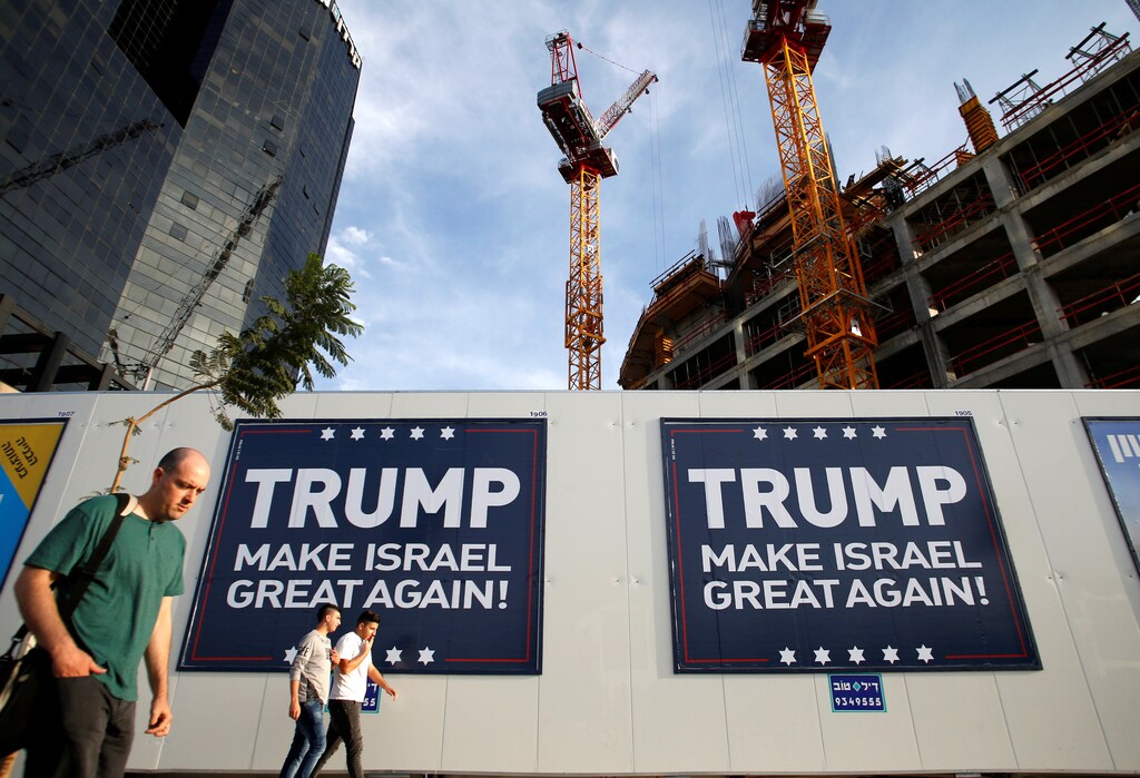 People walk past signs bearing the name of U.S. President-elect Republican Donald Trump in Tel Aviv, Israel November 14, 2016. REUTERS/Baz Ratner - RTX2TLRV