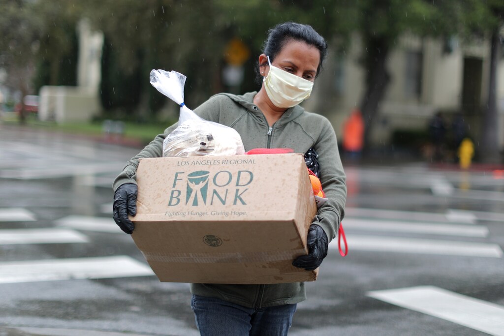 A woman carries away fresh food at a Los Angeles Regional Food Bank giveaway of 2,000 boxes of groceries, as the spread of the coronavirus disease (COVID-19) continues, in Los Angeles, California, U.S., April 9, 2020. REUTERS/Lucy Nicholson - RC281G95ISBZ