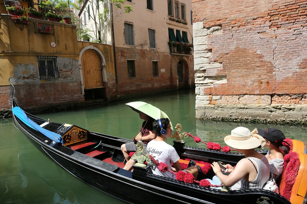 Tourists enjoy a ride on gondola's along a canal near St.Mark's square in Venice, Italy, August 3, 2017. Picture taken on August 3, 2017. REUTERS/Stefano Rellandini - RC11AD30BAB0
