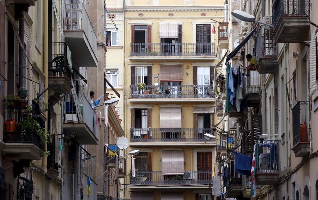 Men speak from balconies at Barceloneta neighborhood in Barcelona, Spain, August 18, 2015. Barcelona's new mayor is picking a fight with home rental websites as she tries to crack down on uncontrolled tourism that she fears could drive out poor residents and spoil the Catalan capital's charm. Picture taken on August 18, 2015. REUTERS/Albert Gea - GF10000182213