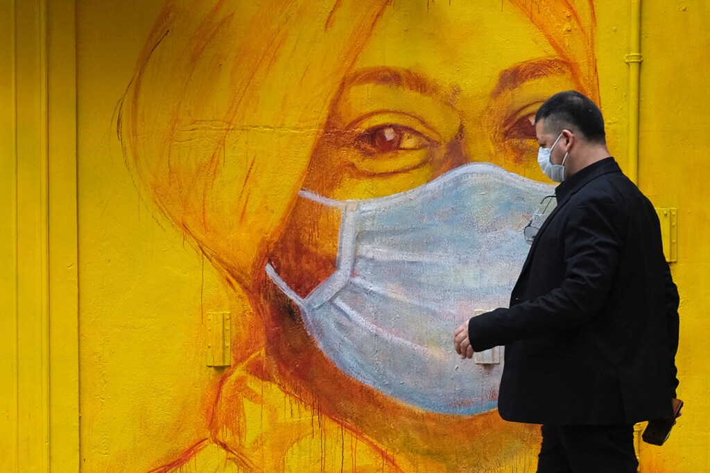 A man with protective mask walks on the street, following the novel coronavirus disease (COVID-19) outbreak, in Hong Kong, China March 27, 2020. REUTERS/Tyrone Siu - RC29SF9EMQ4W