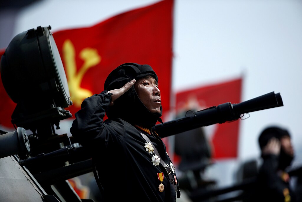 A soldier salutes from atop an armoured vehicle as it drives past the stand with North Korean leader Kim Jong Un during a military parade marking the 105th birth anniversary of country's founding father Kim Il Sung, in Pyongyang April 15, 2017. The man is wearing the uniform of a North Korean tank commander. His pose, the direction he is looking and the flags of both the ruling Workers Party of Korea and the Korean Peoples Army on the vehicles are deliberately placed to evoke the composition used in North Korean propaganda style. REUTERS/Damir Sagolj SEARCH "PARADE WID" FOR THIS STORY. SEARCH "WIDER IMAGE" FOR ALL STORIES. - RTS12G5P