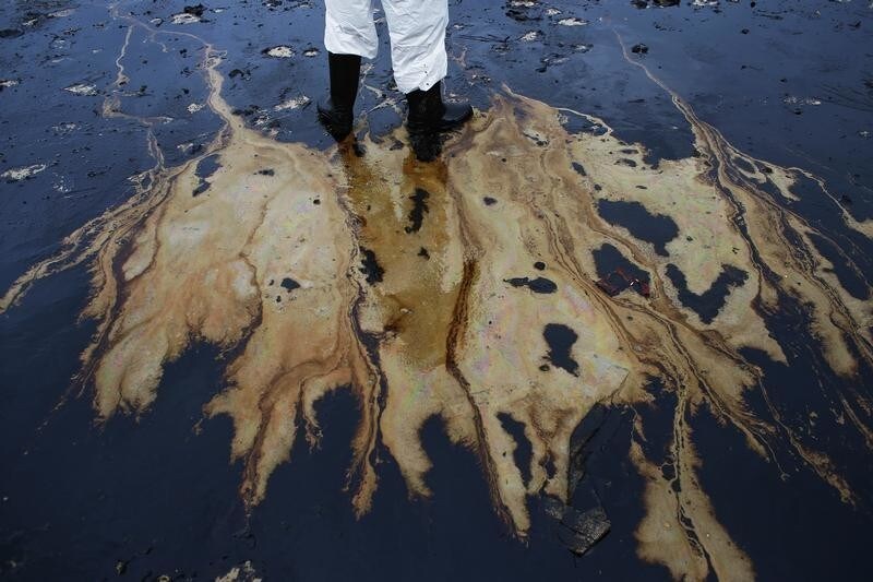 A Thai soldier in white biohazard suit takes part in a clean-up operation at Ao Prao Beach on Koh Samet, Rayong July 30, 2013. Crude oil that leaked from a pipeline in the Gulf of Thailand over the weekend has reached a Thai tourist resort, pipeline operator PTT Global Chemical Pcl said on Monday. Around 50,000 litres of crude oil poured into the sea on Saturday around 20 km (12 miles) off the coast of Rayong, southeast of the capital Bangkok. REUTERS/Athit Perawongmetha (THAILAND - Tags: DISASTER ENVIRONMENT) - GM1E97U186Q01