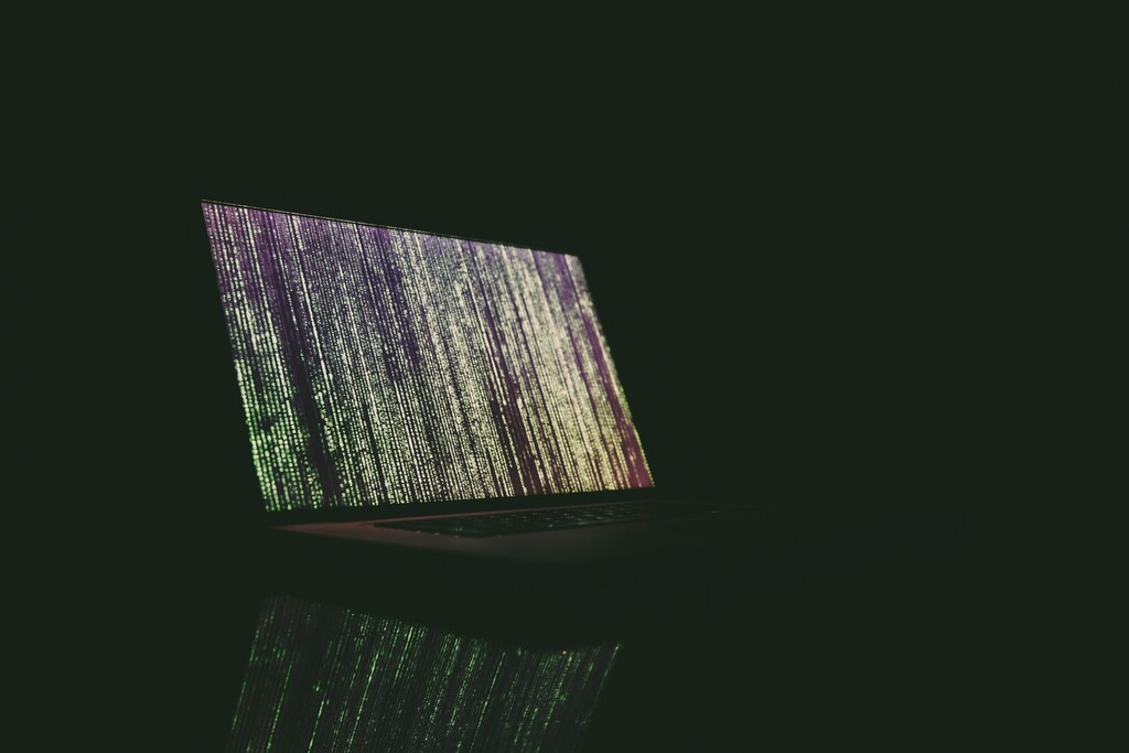 The invasion of Ukraine has resulted in numerous digital safety challenges. Pictured here: A laptop with lines of codes on the screen in a dark room.