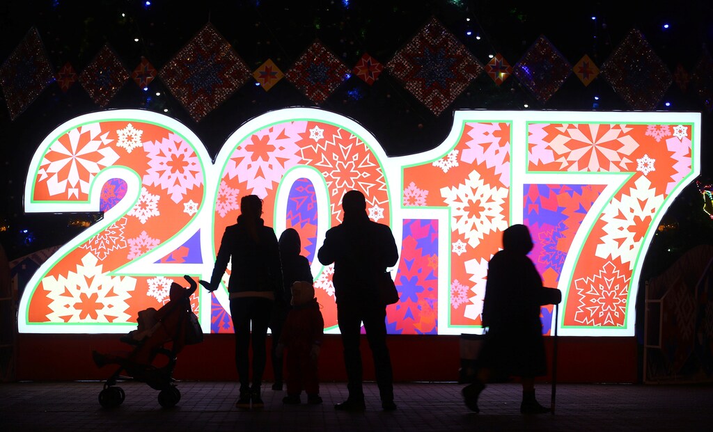 People are seen in front of big numbers reading 2017 at Oktyabrskaya Square for the upcoming New Year and Christmas season in Minsk, Belarus December 21, 2016. REUTERS/Vasily Fedosenko - RTX2W25H