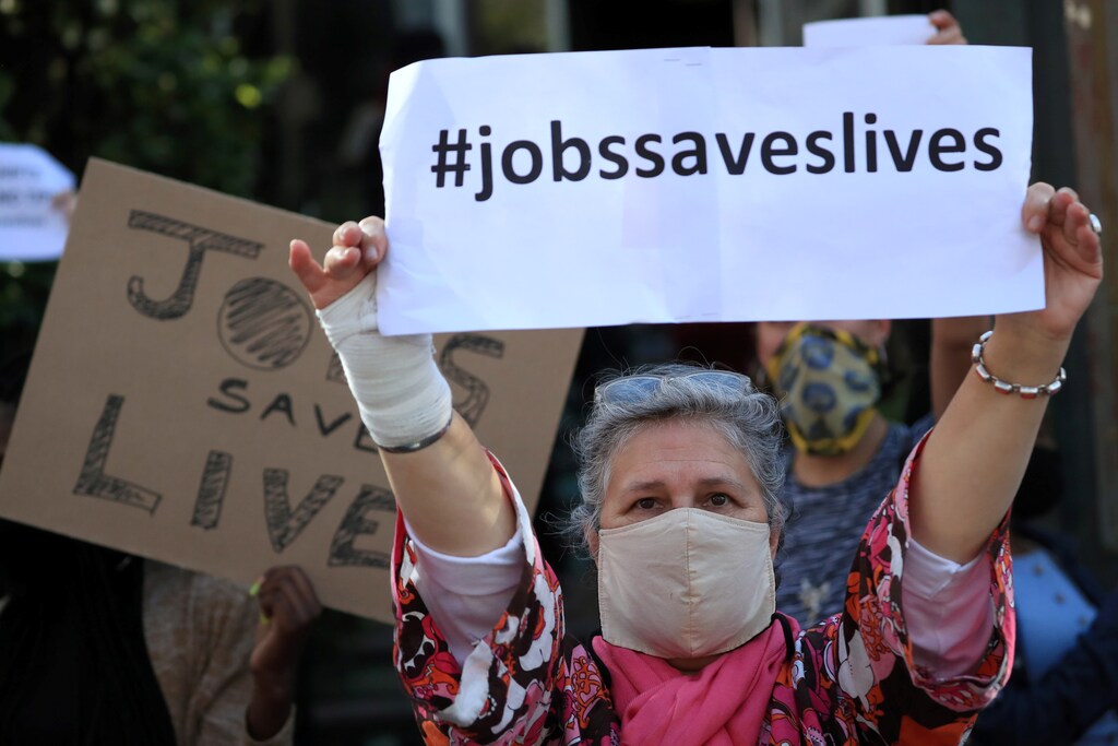 A restaurant worker holds a placard during a protest against the coronavirus disease (COVID-19) restrictions in Cape Town, South Africa, July 22, 2020. REUTERS/Mike Hutchings - RC2BYH9NMQES