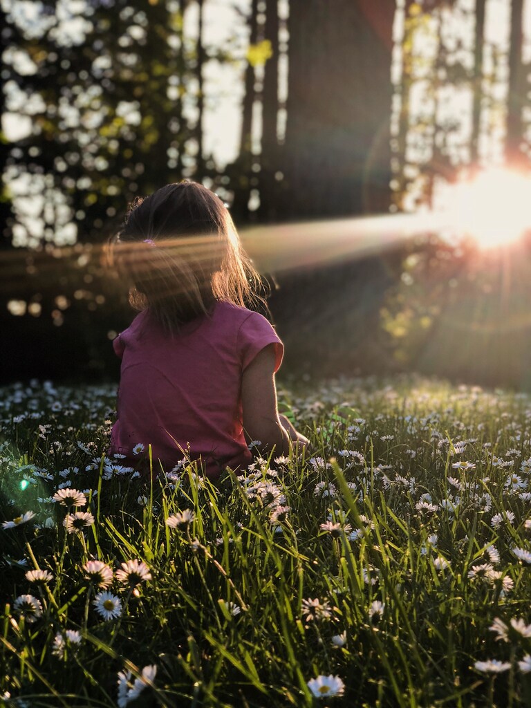 child looking towards sunlight coming through the trees illustrating potential for European Green Deal