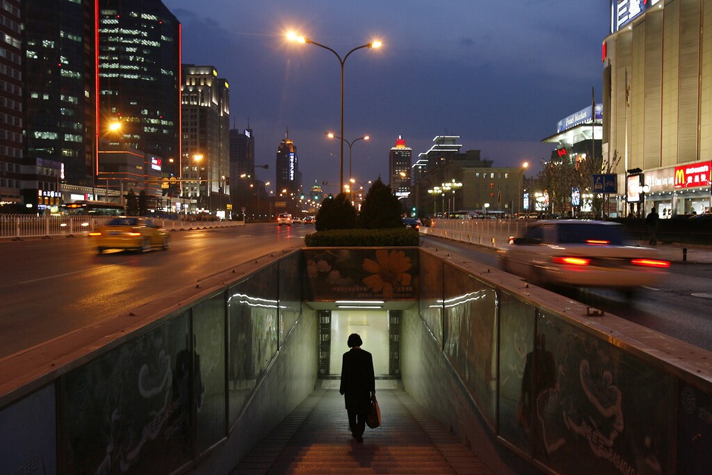 A woman walks into a subway in the central business district of Beijing April 16, 2007. China's economy probably gathered pace in the first quarter, partly on the back of resurgent loan growth and underscoring the need for Beijing to take further tightening steps in the months ahead. The median forecast of 12 economists polled by Reuters was for gross domestic product to have grown by 11.0 percent from a year earlier in the January-March period. REUTERS/Claro Cortes IV (CHINA) - RTR1OOZ4