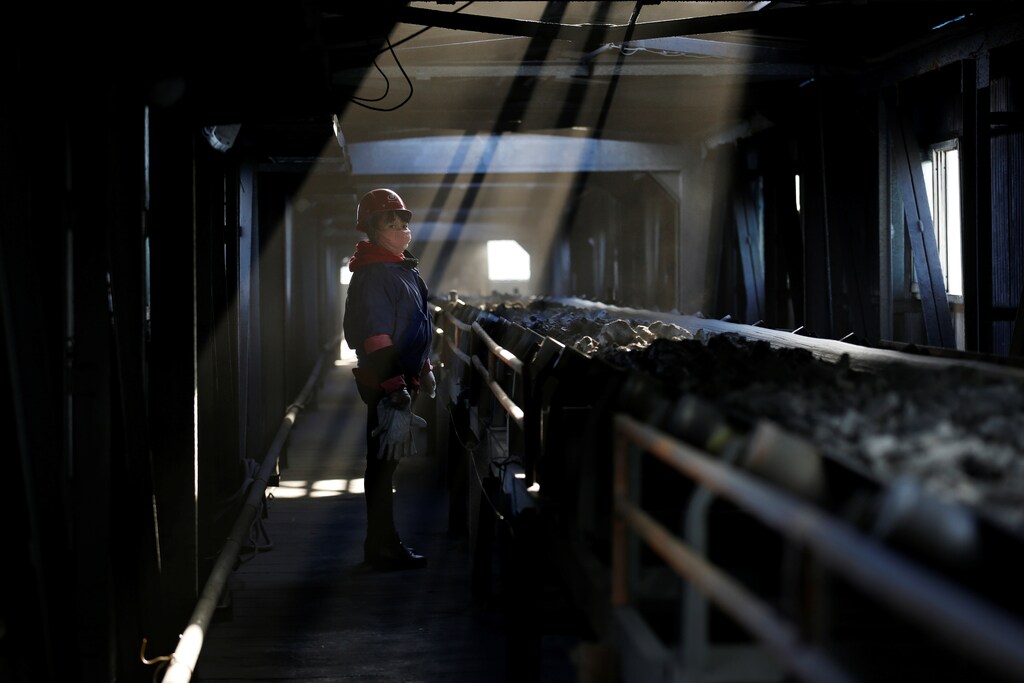 A worker inspects a conveyor belt carrying coal at a coal coking plant in Yuncheng, Shanxi province, China January 31, 2018.