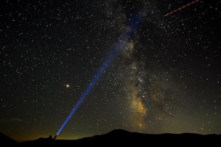 A man points his light at the Milky Way during the peak of the Perseid meteor shower at Mavrovo national park in Macedonia August 12, 2018. REUTERS/OgnenTeofilovski TPX IMAGES OF THE DAY